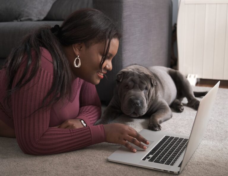 African woman in sportswear laying on the floor using a laptop at home. | How to Research SEO on Google Search