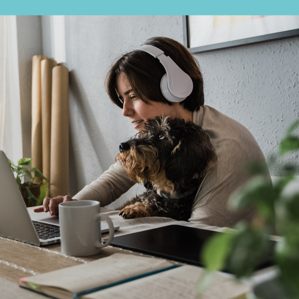 Man wearing headphones with dog at computer