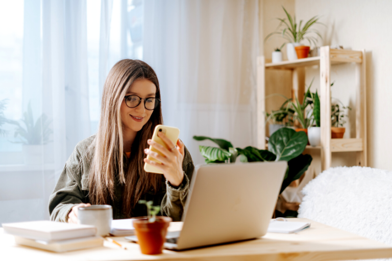 woman smiling at her cellphone | 7 Best Practices for Creating Mobile-Friendly Emails